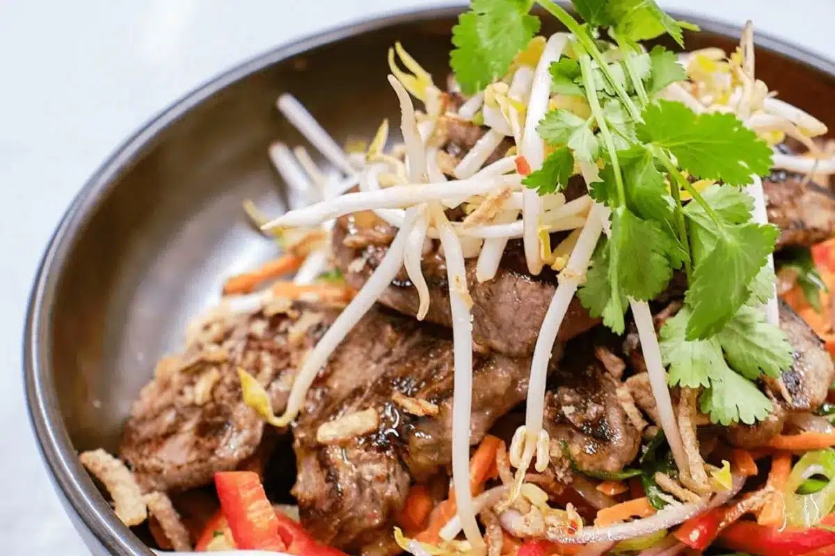 A bowl filled with colorful vegetables and meat protein, showcasing a vibrant and appetising meal.