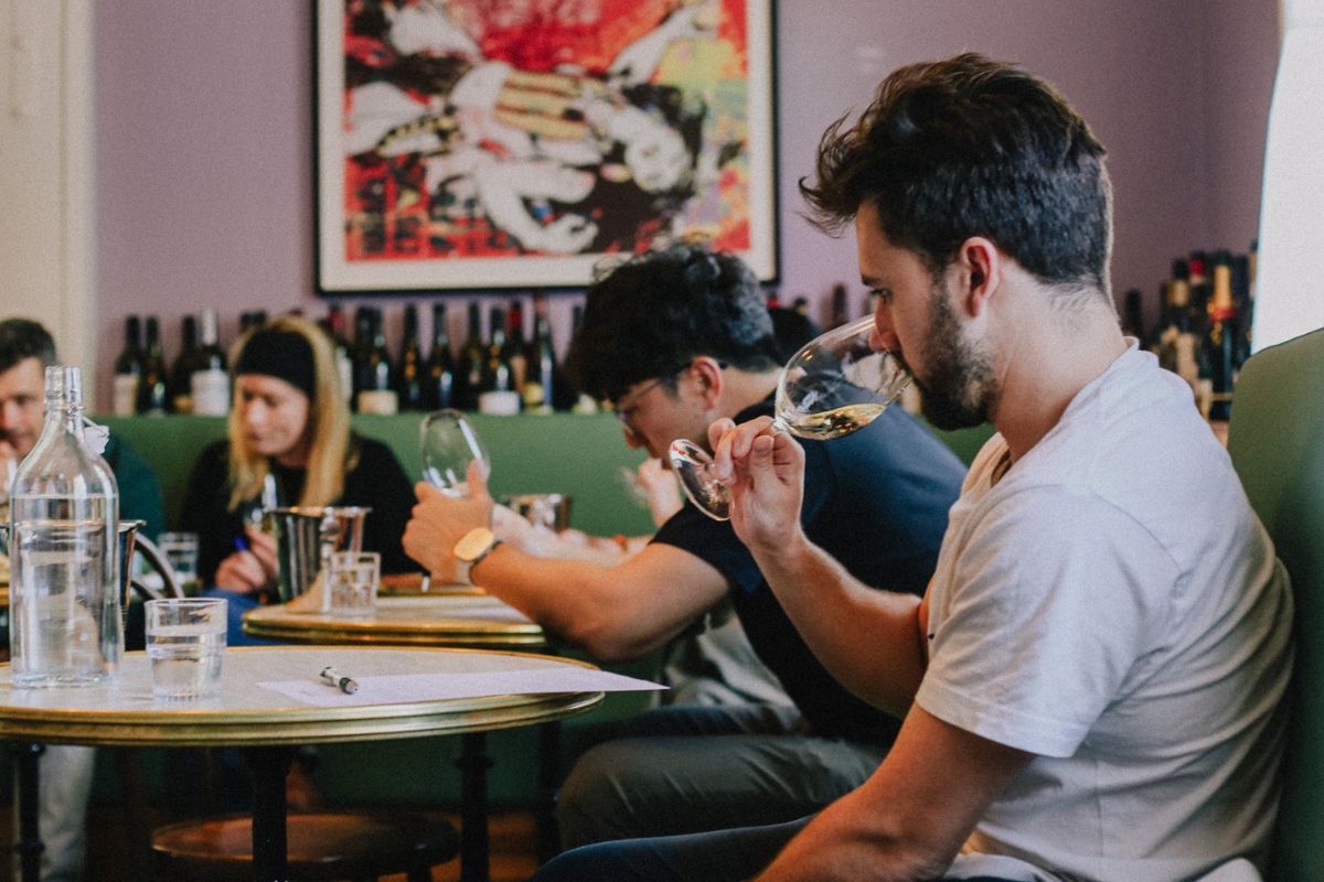 A group of people sit in a restaurant blind tasting a selection of wines in South Australia.