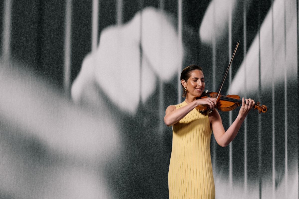 Adelaide Symphony Orchestra violinist plays a solo wearing a yellow dress.