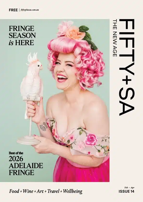 FIFTY+SA magazine issue 14 cover photo featuring a smiling woman with pink hair holding a statue of a galah