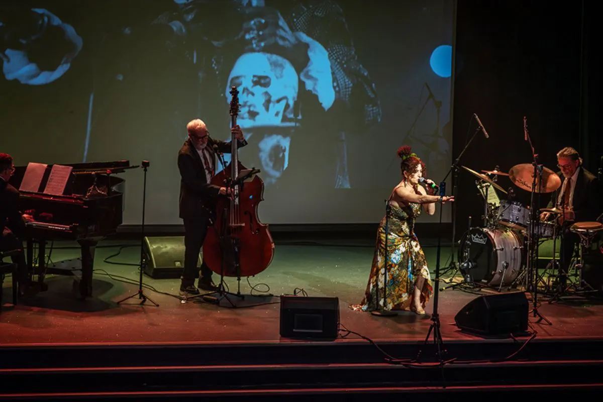 A 3 piece jazz band performs on stage with a captivating singer.