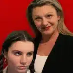 A woman poses proudly with her student daughter.