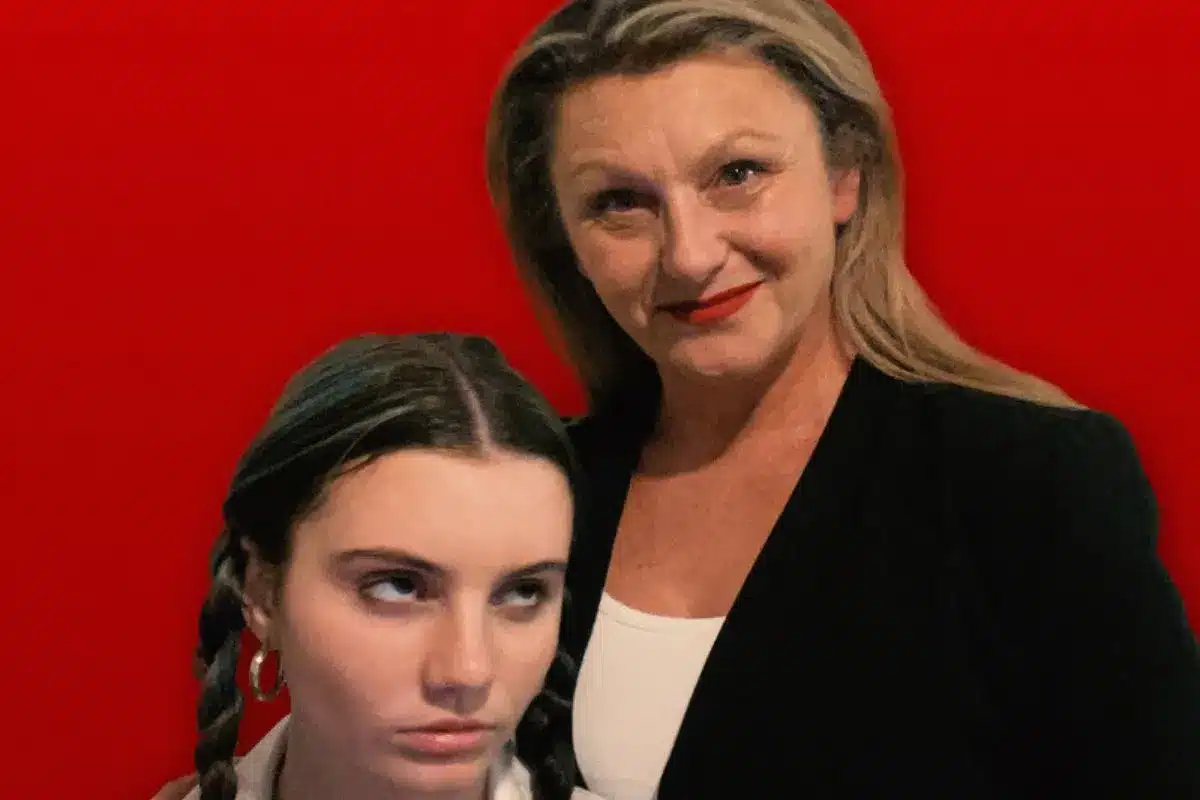 A woman poses proudly with her student daughter.