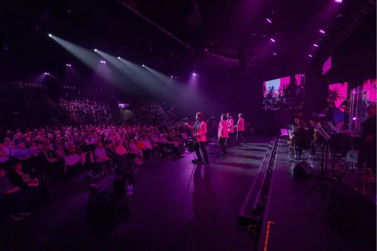 A group of four men perform on stage