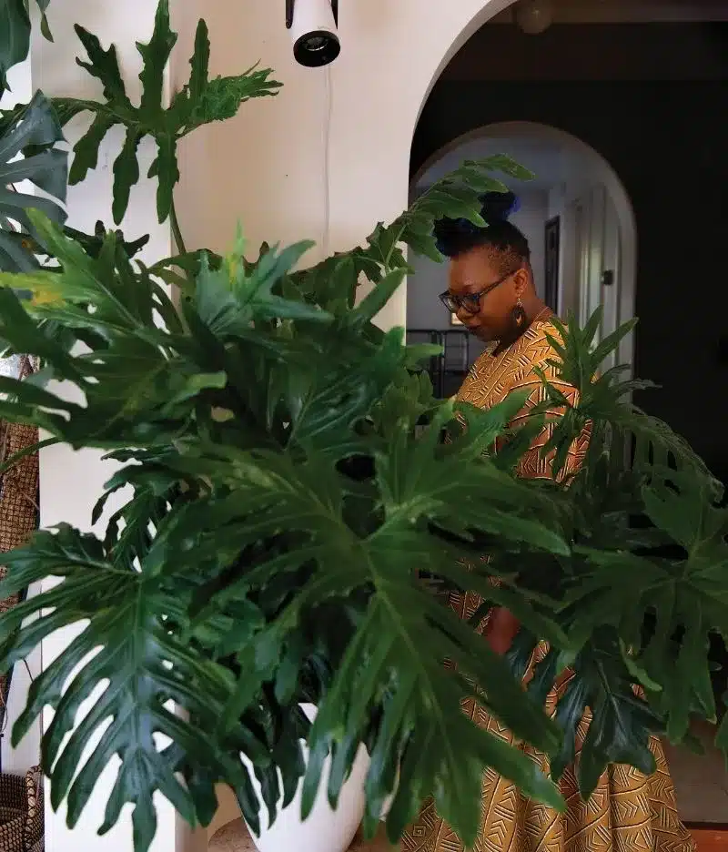 Dr Nora Mutalima tending to plants in her home.