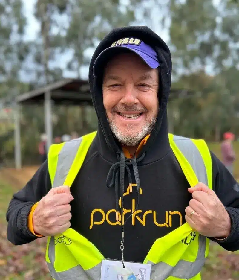 Man dressed in Park Run hooded jumper and high visibility jacket.