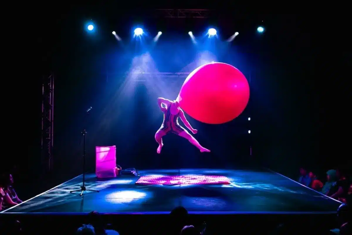 A man in a leotard with a giant balloon for a head performs on stage Adelaide Fringe - The Giant Balloon Show.