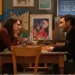 Film Somebody to Love, 2025. Man and a woman sat opposite each other in a restaurant.