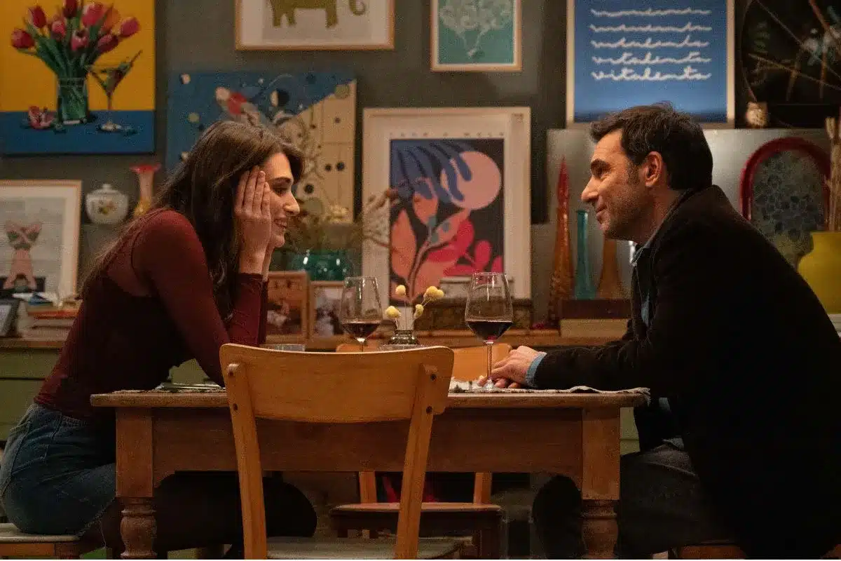 Film Somebody to Love, 2025. Man and a woman sat opposite each other in a restaurant.