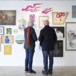An older couple admire art in an art gallery.