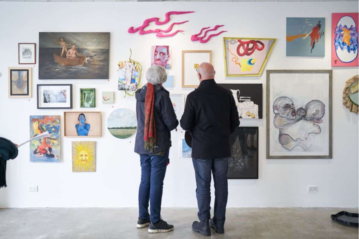An older couple admire art in an art gallery.