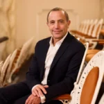 ASO Conductor Mark Wigglesworth seated in theatre isles.