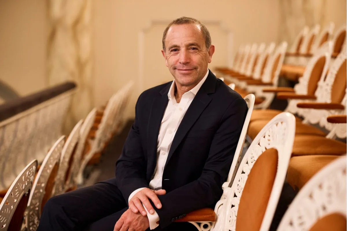 ASO Conductor Mark Wigglesworth seated in theatre isles.