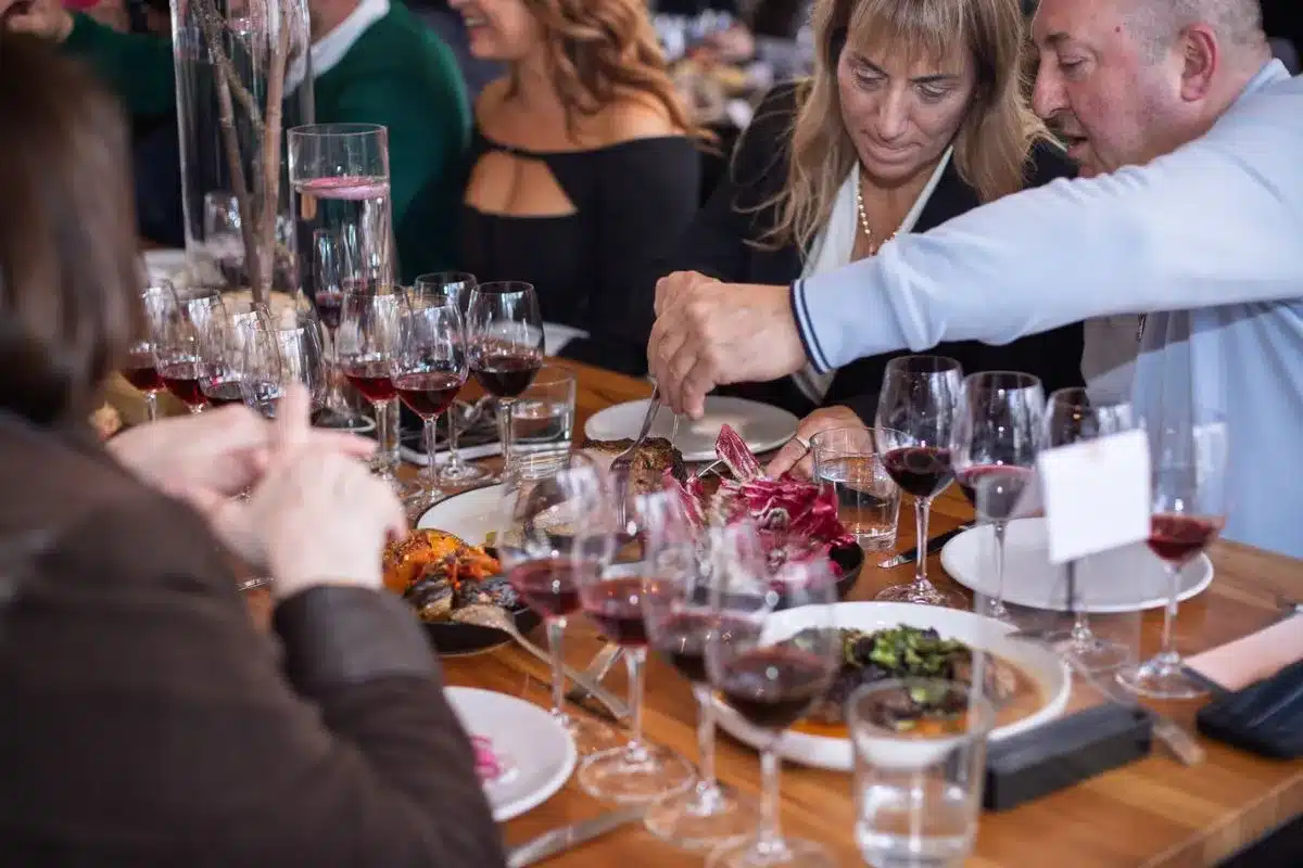 Guests sharing a long-table feast with red wine at the 2025 Winter Reds Festival in the Adelaide Hills. Photo credit: Eat Media.