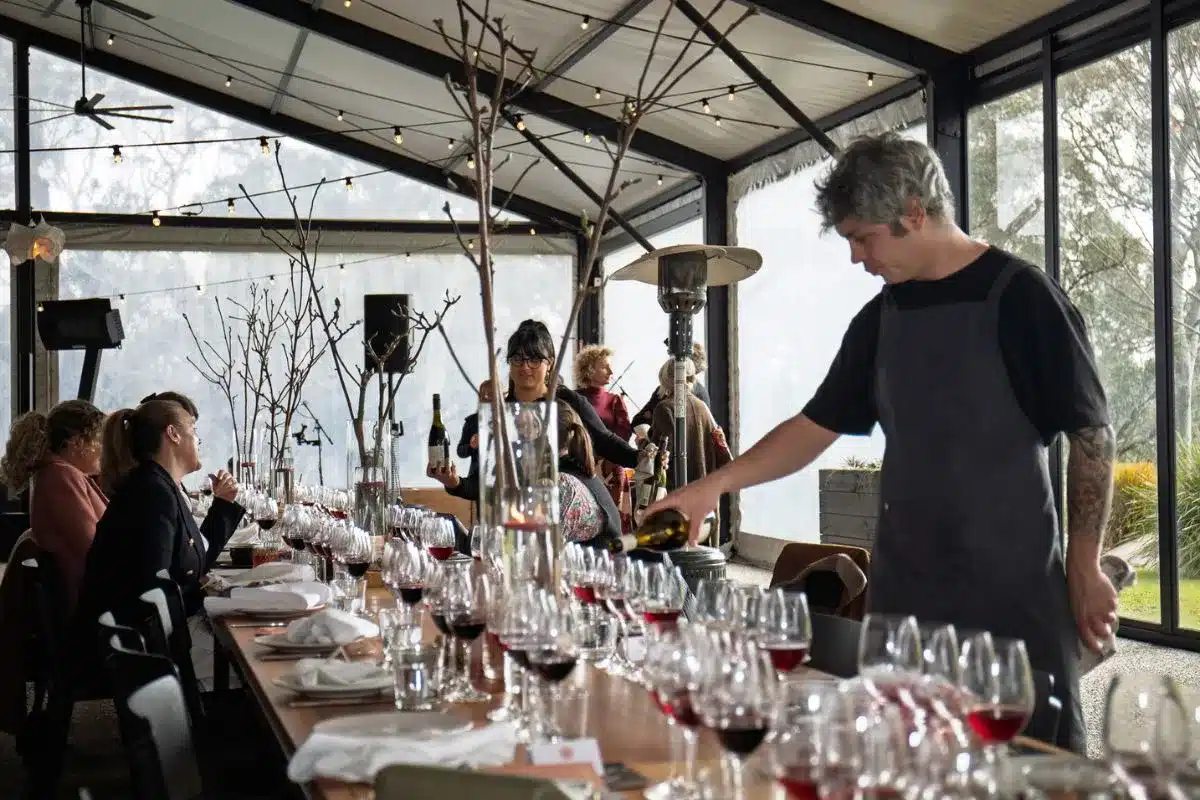 A server pouring red wine at a Winter Reds tasting event in the Adelaide Hills. Photo credit: Eat Media.