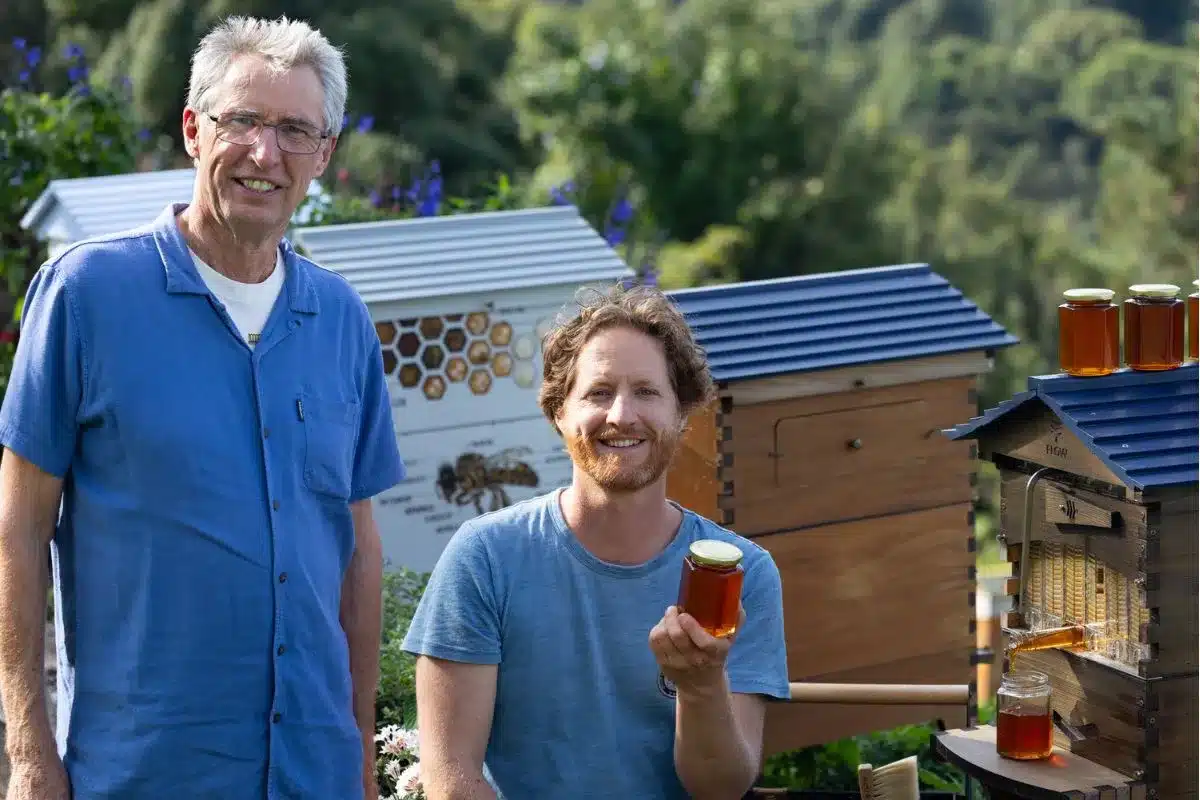 Beekeepers with their beehive and honey.