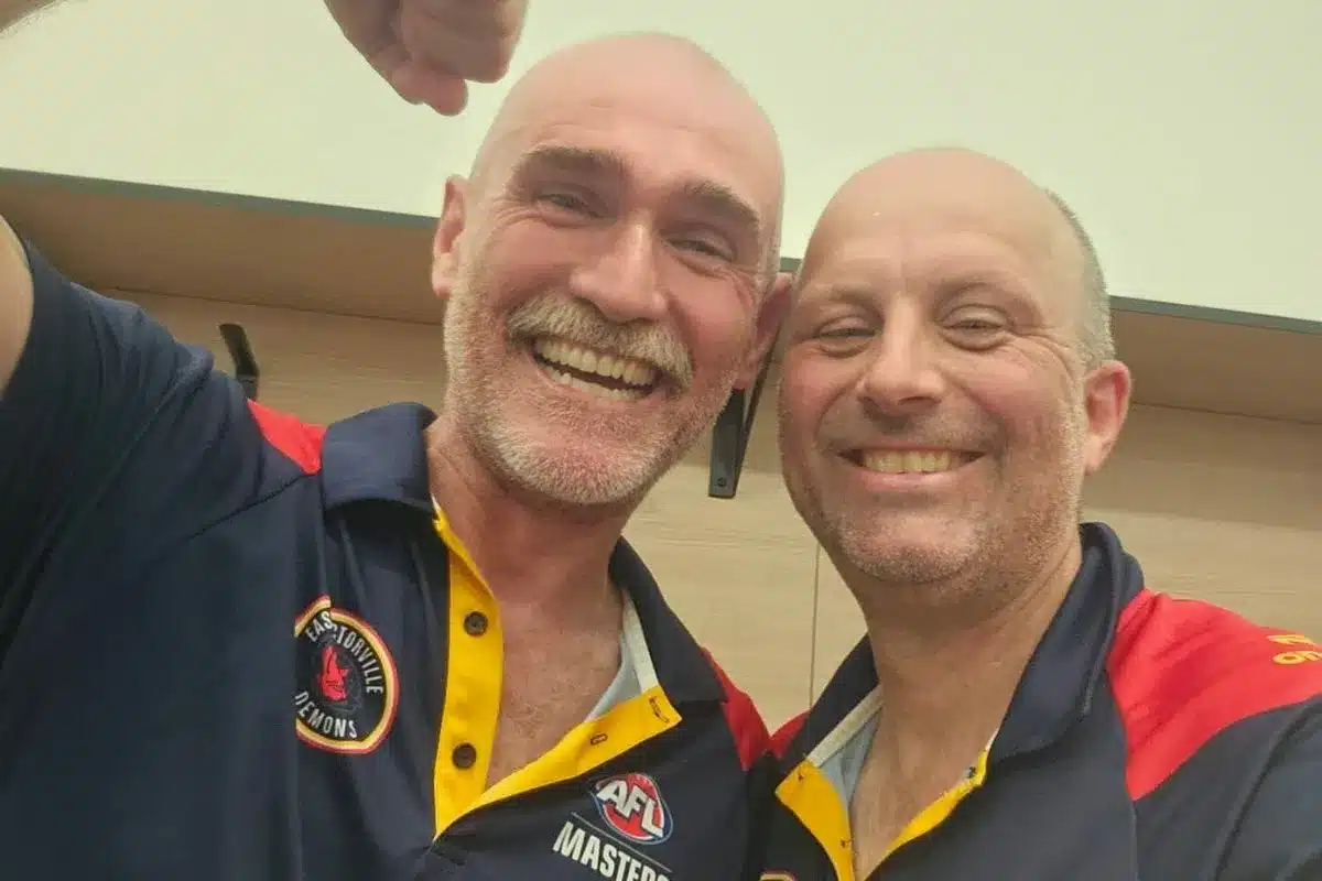 A post-match proof of life photo shared after an AFL Masters game - two smiling men in navy AFL Masters polos.