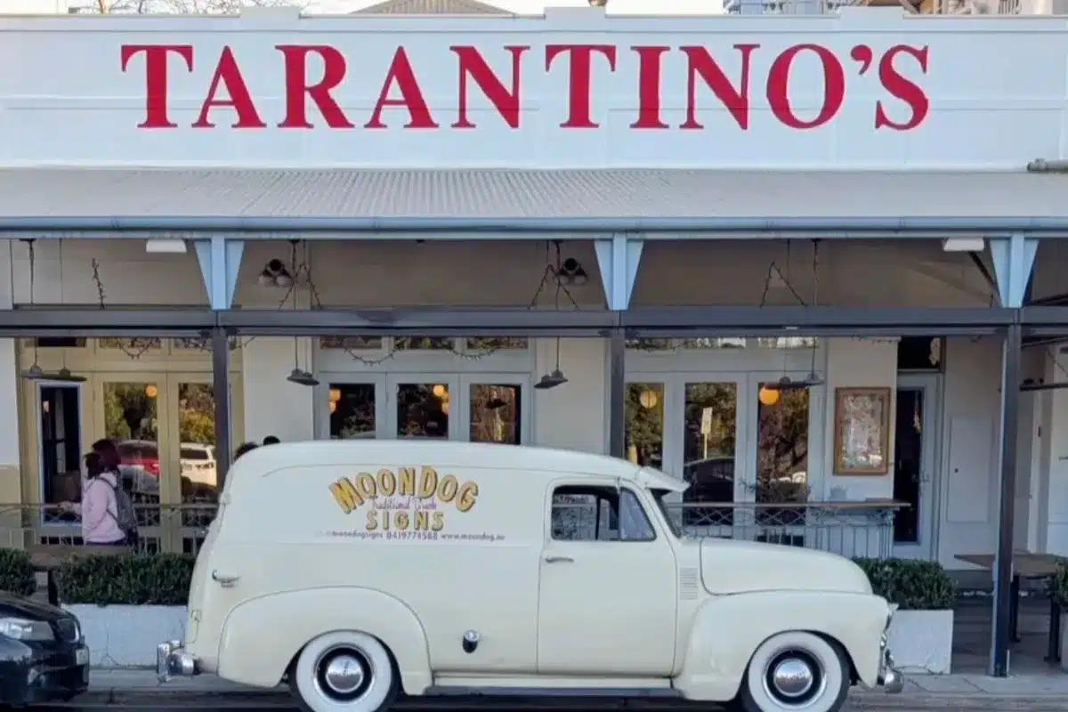 Bold red hand-painted Tarantino's signage above the entrance, with the MoonDog signs van parked outside.