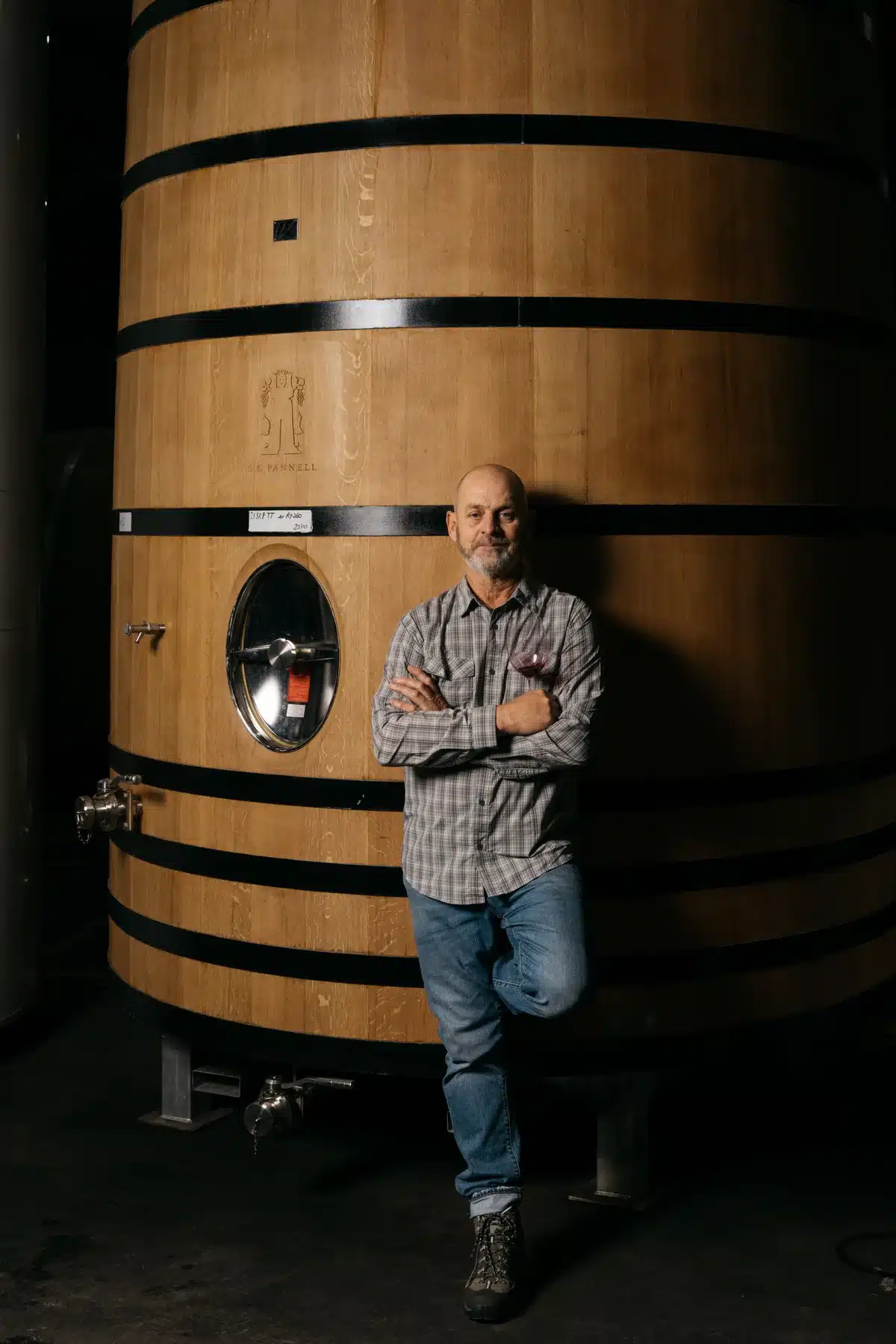 A winemaker from Koomilya standing beside an oak barrel in the cellar.