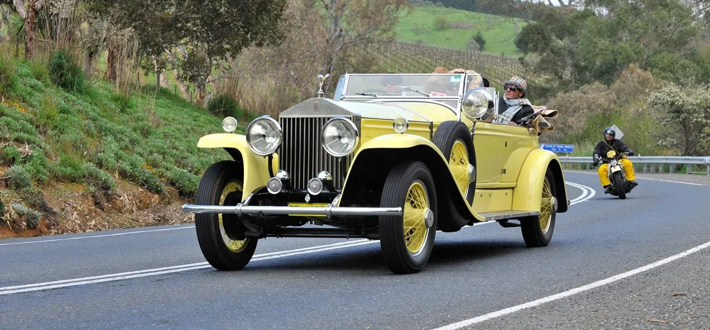 Vintage yellow classic car driving during the Bay to Birdwood historic motoring event.